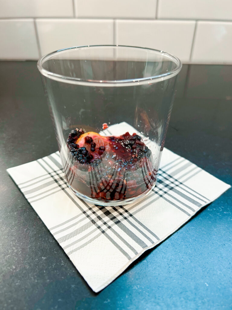 blackberries and lemon muddled in glass